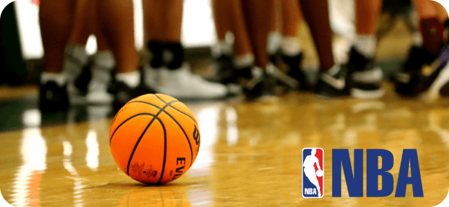 Um maestro regendo a Orquestra Filarmônica de Auckland em uma grande sala de concertos.